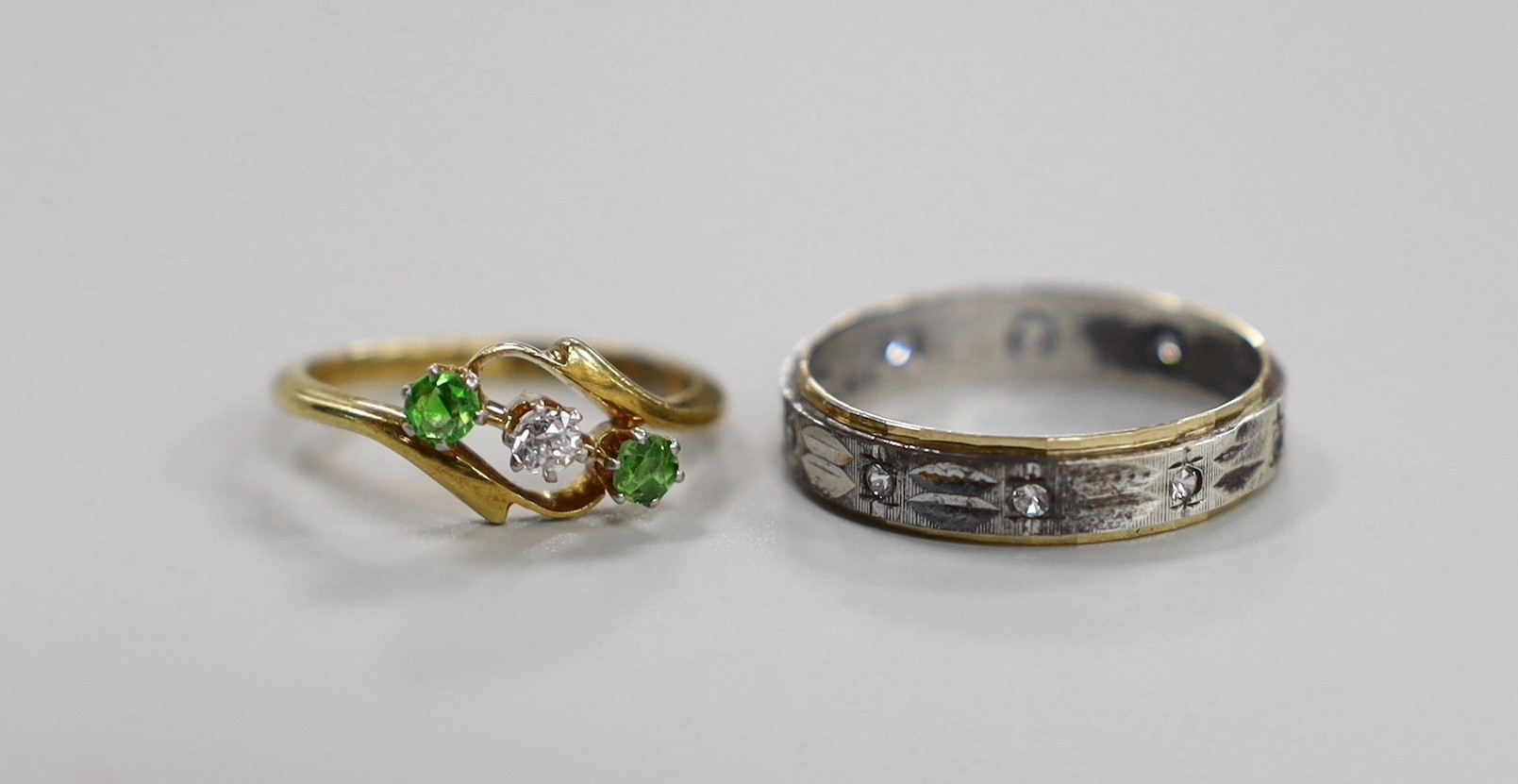 An 18ct and pt, diamond and green garnet set three stone crossover ring, size I/J, gross 2.5 grams and one other ring stamped '9ct and silver'.